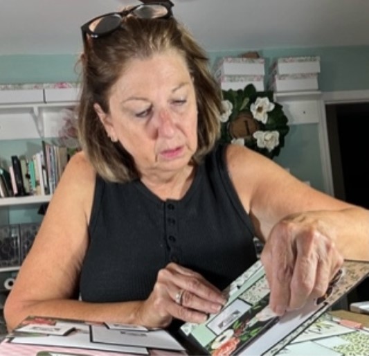 creator at her craft desk working on a scrapbook