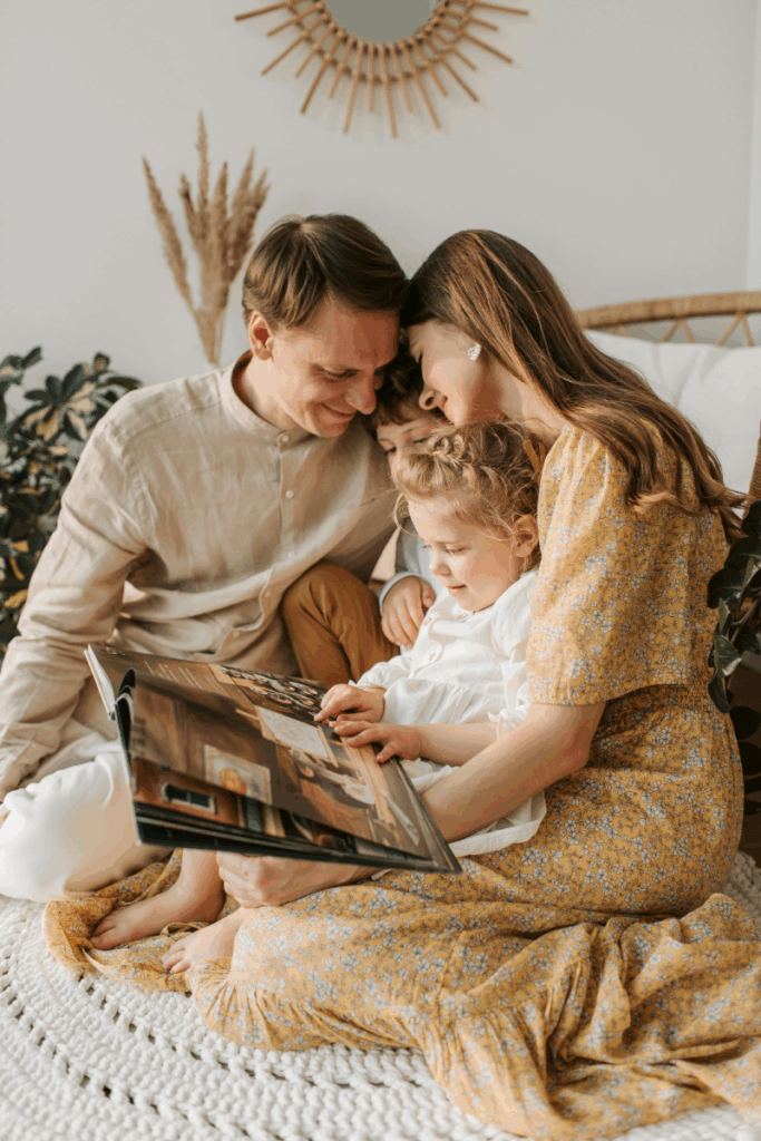 Family in a cozy setting while looking at a scrapbook. 