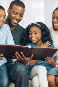 Close knit family with all smiles, looking at a scrapbook. 