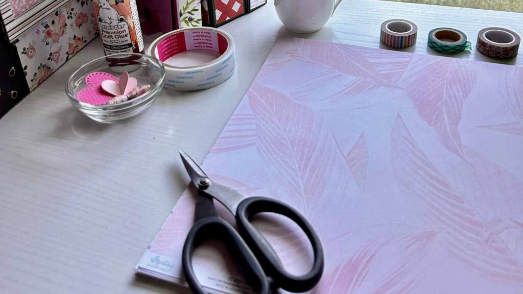 desk scene with scissors, paper and neatly set of books