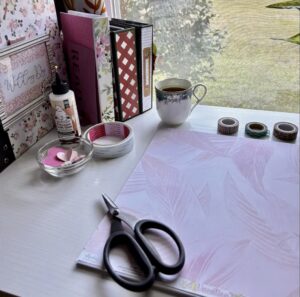 clean calm desk scene with scissors, scrapbooks, and patterned paper